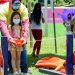 Children enjoying an outdoor game event while wearing face masks for safety.
