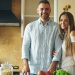 Portrait of loving couple cooking breakfast smiling ang looking into camera in the kitchen at home
